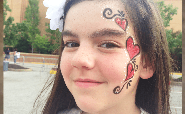 little girl with hearts painted on her face